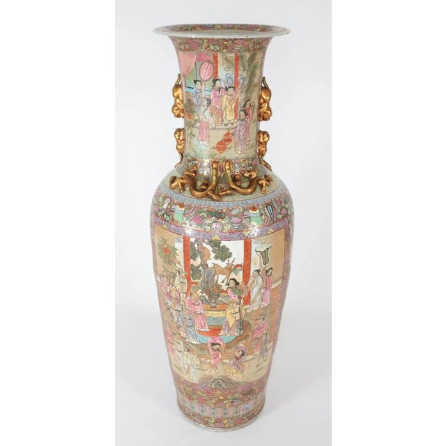 Large pair of hand-painted Cantonese vases in the Family Rose decor with a high neck on which lions and Foo cubs are...