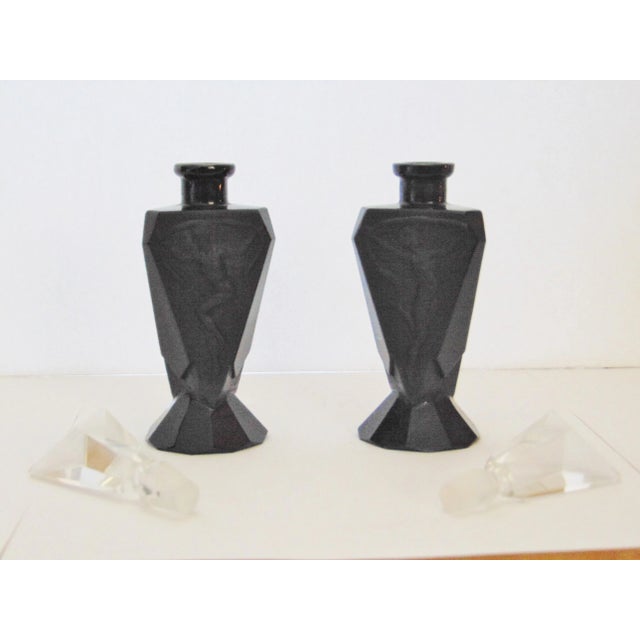 A pair of black glass Art Deco perfume bottles with crystal lid.