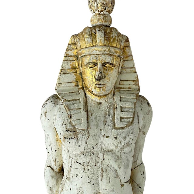 Monumental Egyptian Revival Giltwood Figural Torchères/Candleholders. These torchères are carved in wood with an age worn...