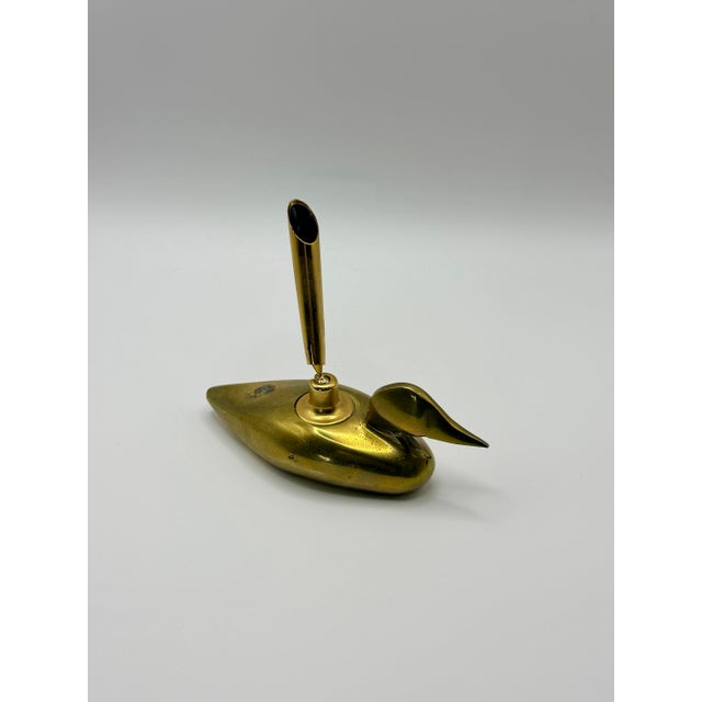 A charming vintage solid brass duck desk accessory featuring a sculptural duck form with an integrated pen holder....