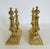 Pair Victorian Aesthetic Movement brass fire dogs. Marked on bases RB109049. Weighted bases. Measures 2-7/8" W X 7-7/8" D...