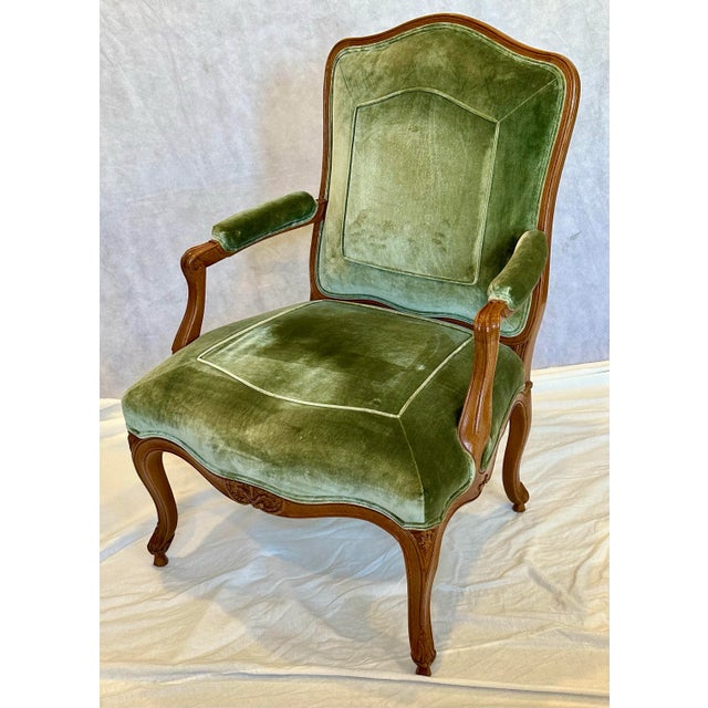 A finely crafted Louis XV style fauteuil lounge chair by J. Robert Scott, featuring a hand-carved wood frame and...