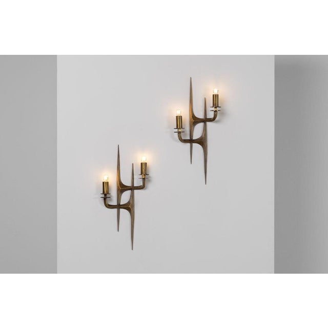 An exceptional pair of sculptural brass wall sconces designed by Angelo Brotto for Esperia, Italy, circa 1970. These...