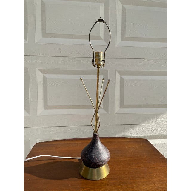 Funky mid century modern starburst atomic table lamp. Brass base and starburst upper with ceramic middle. Slight repaired...