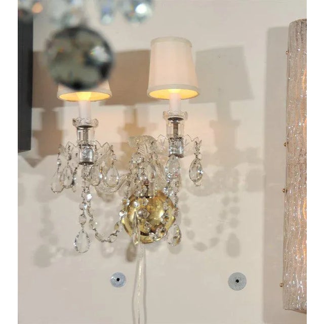 This cut crystal sconce with scrolled arms and tear drop beveled pendants recalls all of the elegant splendor of 1940s...