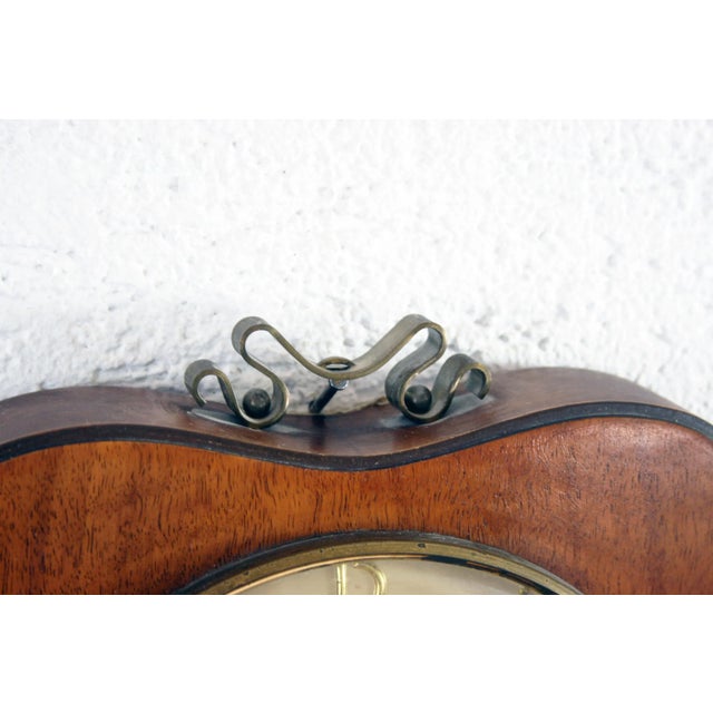 This unusual vintage apple-shaped wall clock from Garant Schwebe Anker features a hinged window to access the clock's...