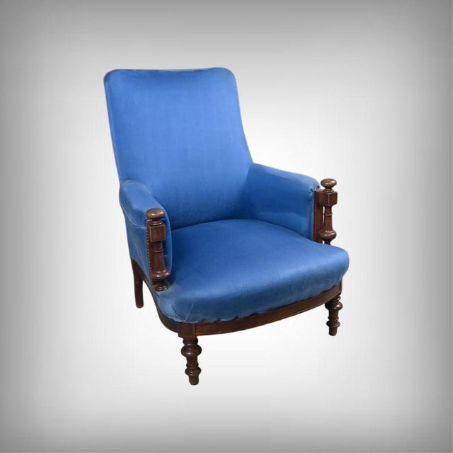 This early 20th-century walnut armchair captivates with the harmonious combination of its wood and deep blue upholstery,...