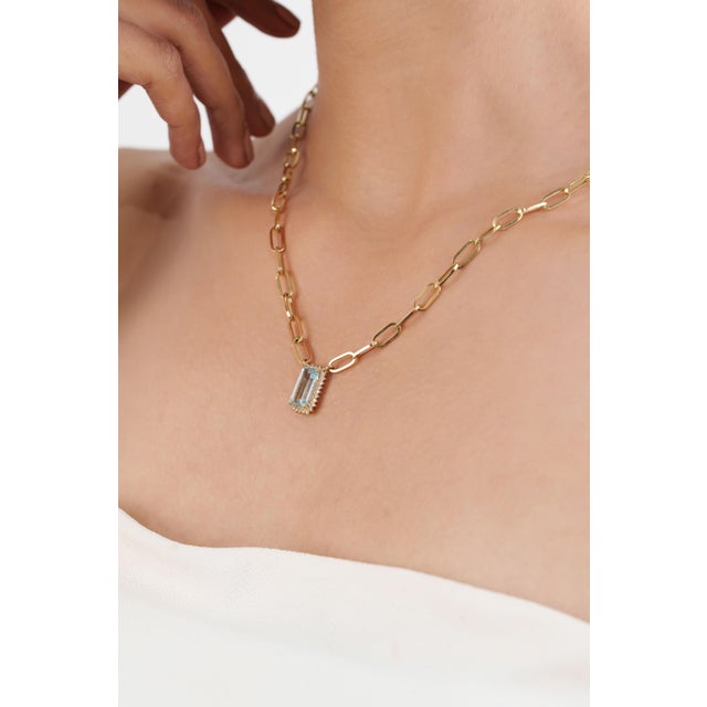 This modern paperclip chain necklace features a 2.26 carat emerald-cut aquamarine, set in 14K yellow gold. The center...