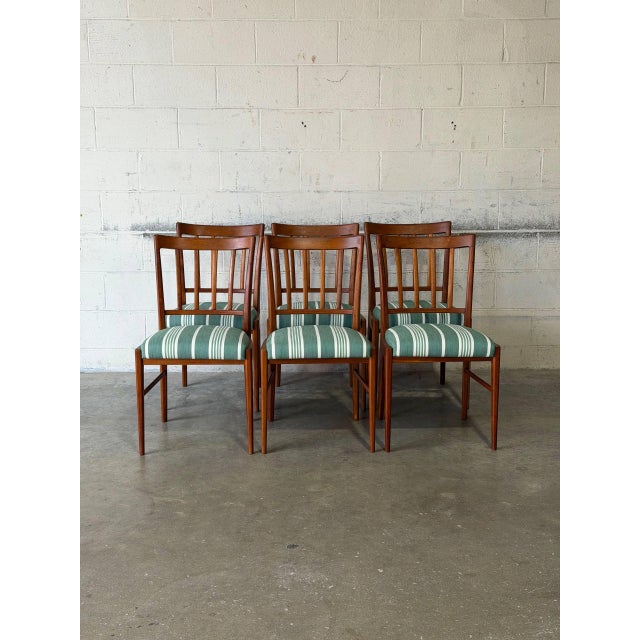 This set of six dining chairs features an open silhouette defined by elegant vertical slat backs. The timeless profile...