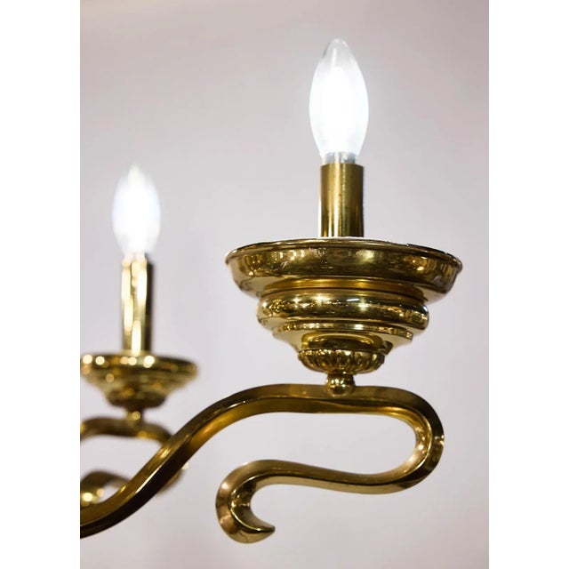 Spanish Mid-Century chandelier of brass having six arms that are traditional in overall form yet wonderfully baroque in...