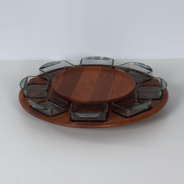 Digsmed Lazy Susan is a Danish snack tray from the 1960s, designed as a rotating teak serving tray with eight glass bowls....