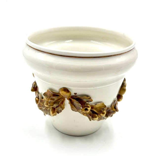A lovely Mid Century petite Italian ceramic white and gold cache pot or planter with a gilded laurel wreath design. Marked...