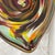 A striking hand-blown Murano glass centerpiece showcasing an expressive vortex design, alive with richly layered tones of...