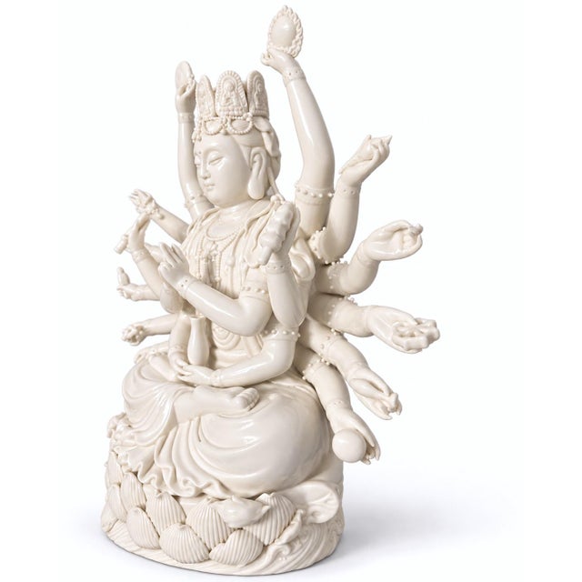 A substantial white-glazed porcelain figure of the multi-armed Guanyin (Avalokiteshvara), the bodhisattva of compassion,...