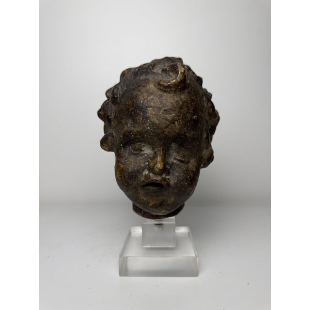 This 16th-century Tuscan terracotta sculpture depicts the head of a cherub with expressive style, strongly modeled facial...