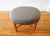 This is a mid century modern oval ottoman with a newly upholstered elephant gray velvet top and solid wood cross base with...