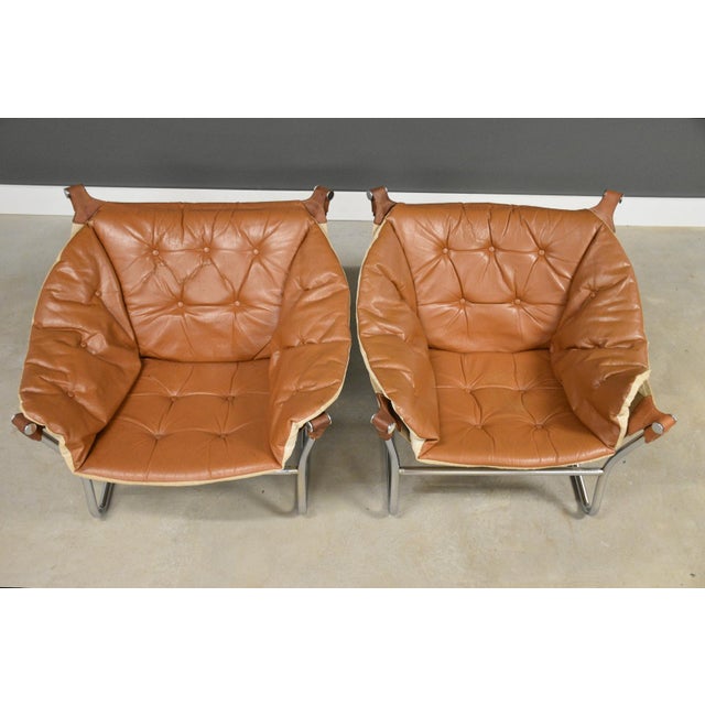 A pair of mid century modern leather sling lounge chairs with polished chrome frames designed by Tormod Alnaes. Circa...