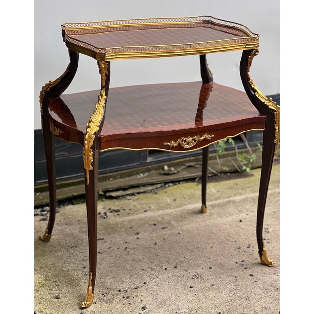 A fine Vintage French Louis XV Style ormolu mounted parquetry two tier table. Real wood and highly skilled craftsmanship...