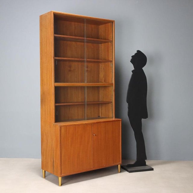 Larch veneer cabinet with brass details, featuring a display case and hinged doors. In good overall condition, with some...