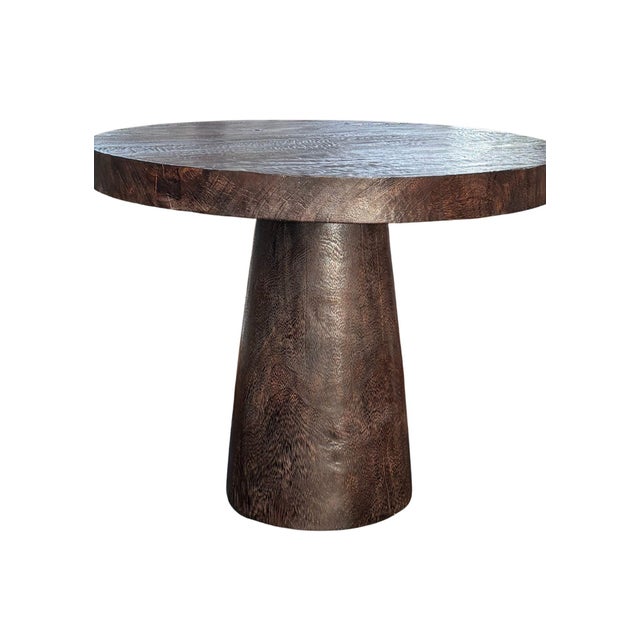 Crafted from solid suar wood, this sculptural pedestal dining table is a refined expression of natural craftsmanship and...