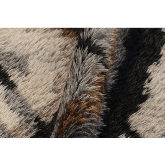 Hand-knotted in lush, high-pile wool in Sweden circa 1960-1970, this 5x7 vintage Swedish Rya rug is a bold new addition to...