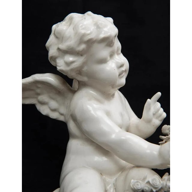 Capodimonte porcelain sculptural group belonging to the early 20th century. The group depicts a putto in a romantic...