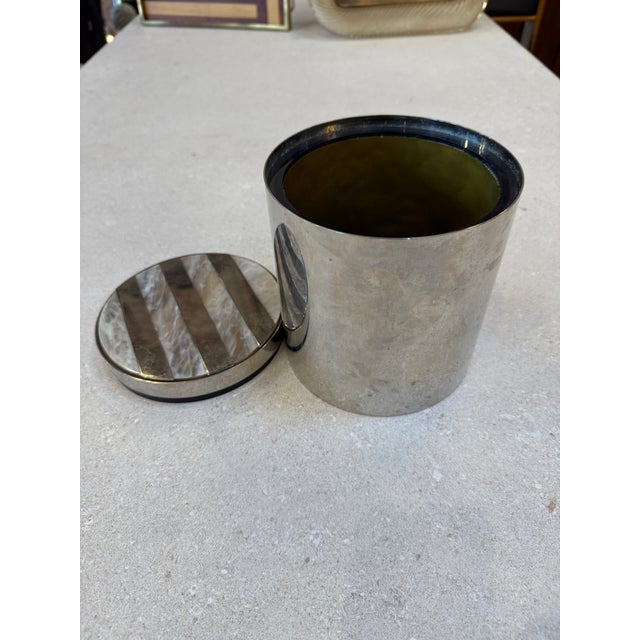 This elegant vintage ice bucket dates to the 1970s and features a cylindrical chrome-plated metal body with a refined,...