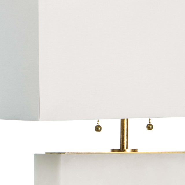 A streamlined base of natural alabaster balances the rectangular shade in this horizontal lamp perfectly. The restrained...