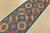 A tribal Caucasian Kazak runner hand-knotted with an all-wool pile on a cotton foundation. This oriental rug features rows...