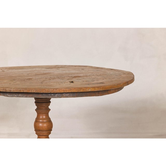 A Dutch Colonial teak wood pedestal table with tripod base. Crafted in the early 20th century, this Dutch Colonial teak...