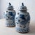 A pair of Chinese blue and white glazed stoneware jars, each with a domed lid surmounted by a seated Buddhist lion, or foo...