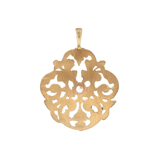 A Victorian repurposed gold pendant featuring intricate hand-pierced and carved scrollwork. Crafted from 18k gold with a...