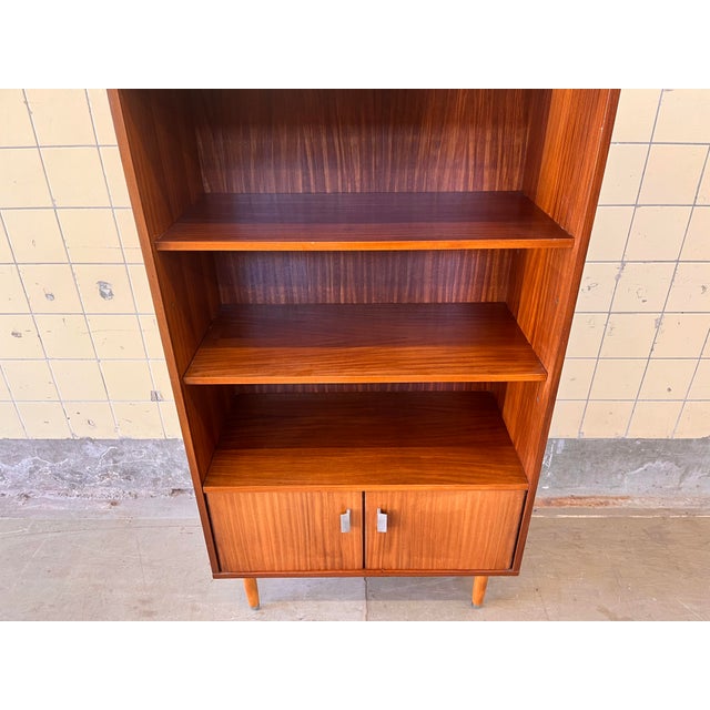 This beautiful vintage bookcase features a refined veneer finish, distinctive metal handles, and a sophisticated high-...