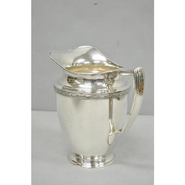 Vintage WMA Rogers Victorian Silver Plated Bulbous Footed Water Pitcher. Circa Mid 20th Century. Measurements: 8.25" H x...