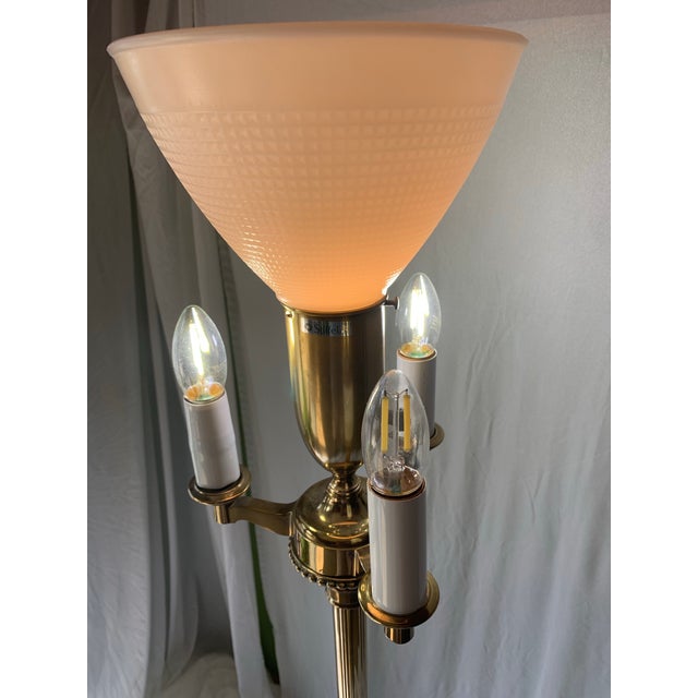This Stiffel 4-Light Torchiere is a brass floor lamp with a milk glass shade. The central milk glass lamp operates on an...