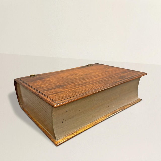 A bit of English whimsy rendered in oak: this 20th-century box takes the form of a book, complete with a hinged “cover”...