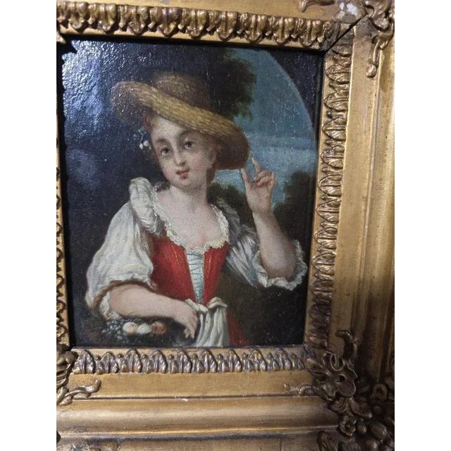 Charming pair of oil paintings on wood panels depicting two young shepherdesses in a bucolic landscape. Each figure,...