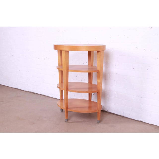 A gorgeous Modern Art Deco style four-tier maple tea table or occasional side table on casters By Baker Furniture USA,...