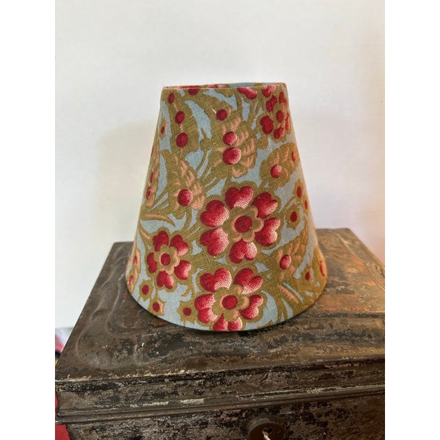 A small clip top shade handmade from an early French floral cotton. Measurements: top 3” bottom 6” side 5.5”