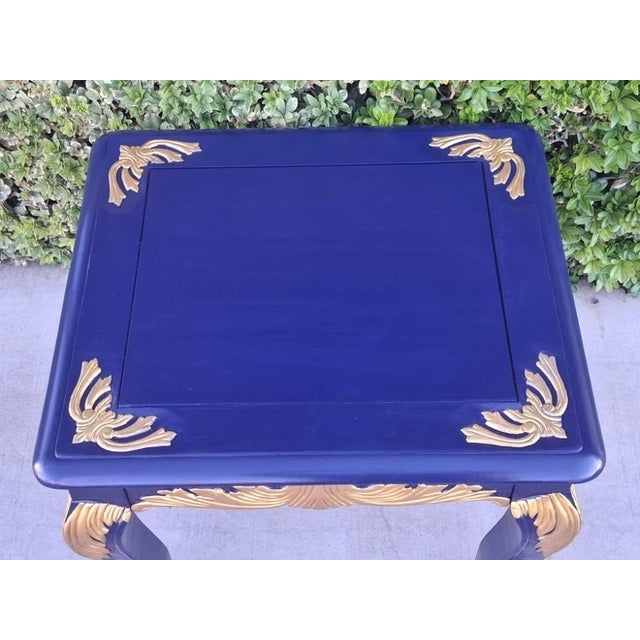 A one-of-a-kind statement accent table bespoke refinished in a deep royal navy blue with radiant metallic gold gilded...