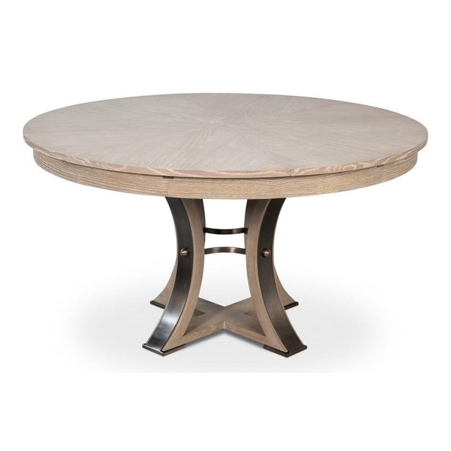 A curved pedestal with dark metal bands gives the circular form a substantial but restrained presence. The round top sits...