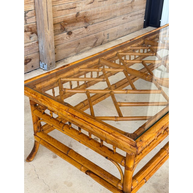 A beautifully crafted vintage bamboo coffee table in the style of Brighton Pavilion, featuring a rectangular glass top,...