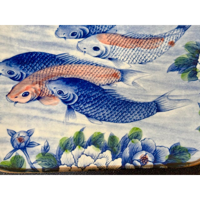Vintage porcelain platter from Japan featuring a detailed design of koi fish, lotus flowers, and pine branches. This item...