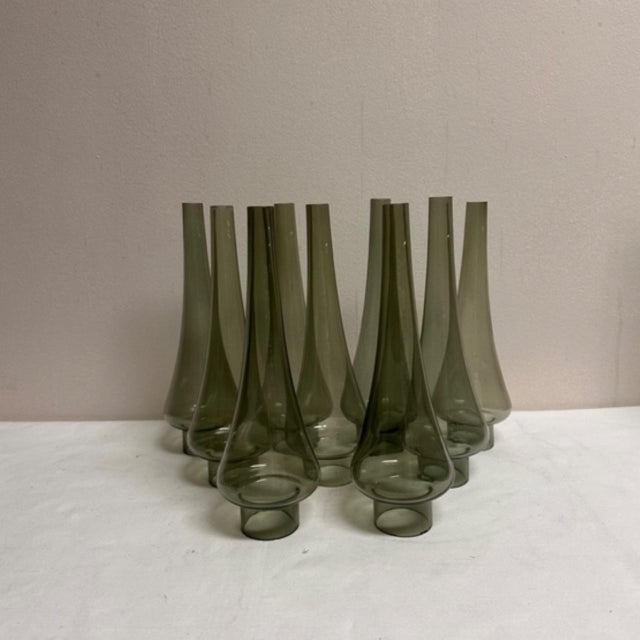 A set of nine smoked glass tapered hurricane style chandelier shades that stand.9.5" H x 1.5"D at top x 3"D opening at...