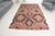 This is a vintage Turkish Oushak rug from the Mid 20th Century. The piece was hand-knotted.