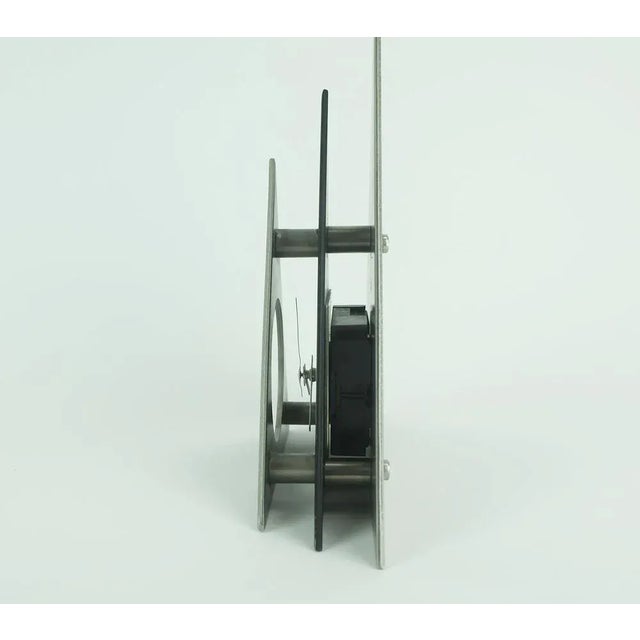 1980s table clock in outstanding design. Made of black and silver gray lacquered metal, white clock hands. Battery works...