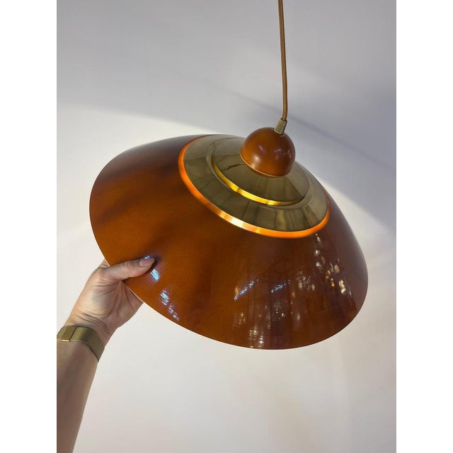 This pendant lamp from Belgium is a gem of mid-century design, perfectly capturing the warm, vibrant aesthetic of the era....
