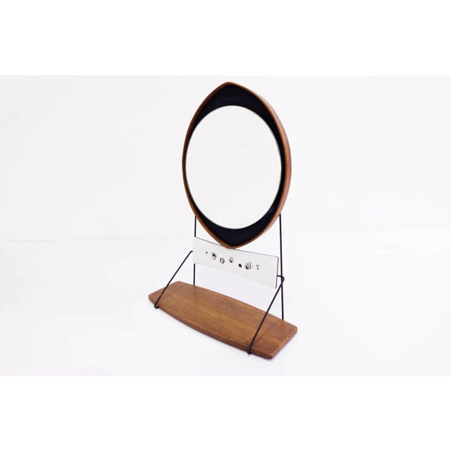 This is an unusual Italian drop mirror with a suspended shelf, circa 1960.