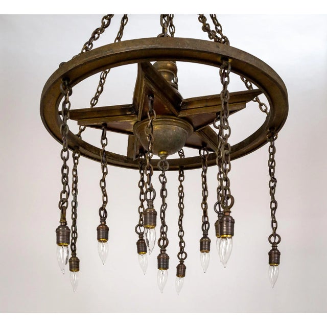 A grand, rustic chandelier with shower hanging lights structured with a downward-facing metal star in a ring with...