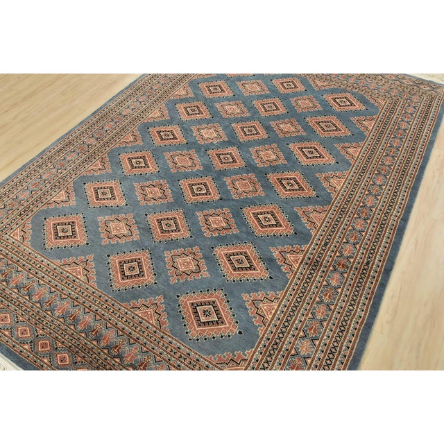 A tribal Bokhara Jaldar rug hand-knotted with an all-wool pile on a cotton foundation. This finely woven oriental rug...